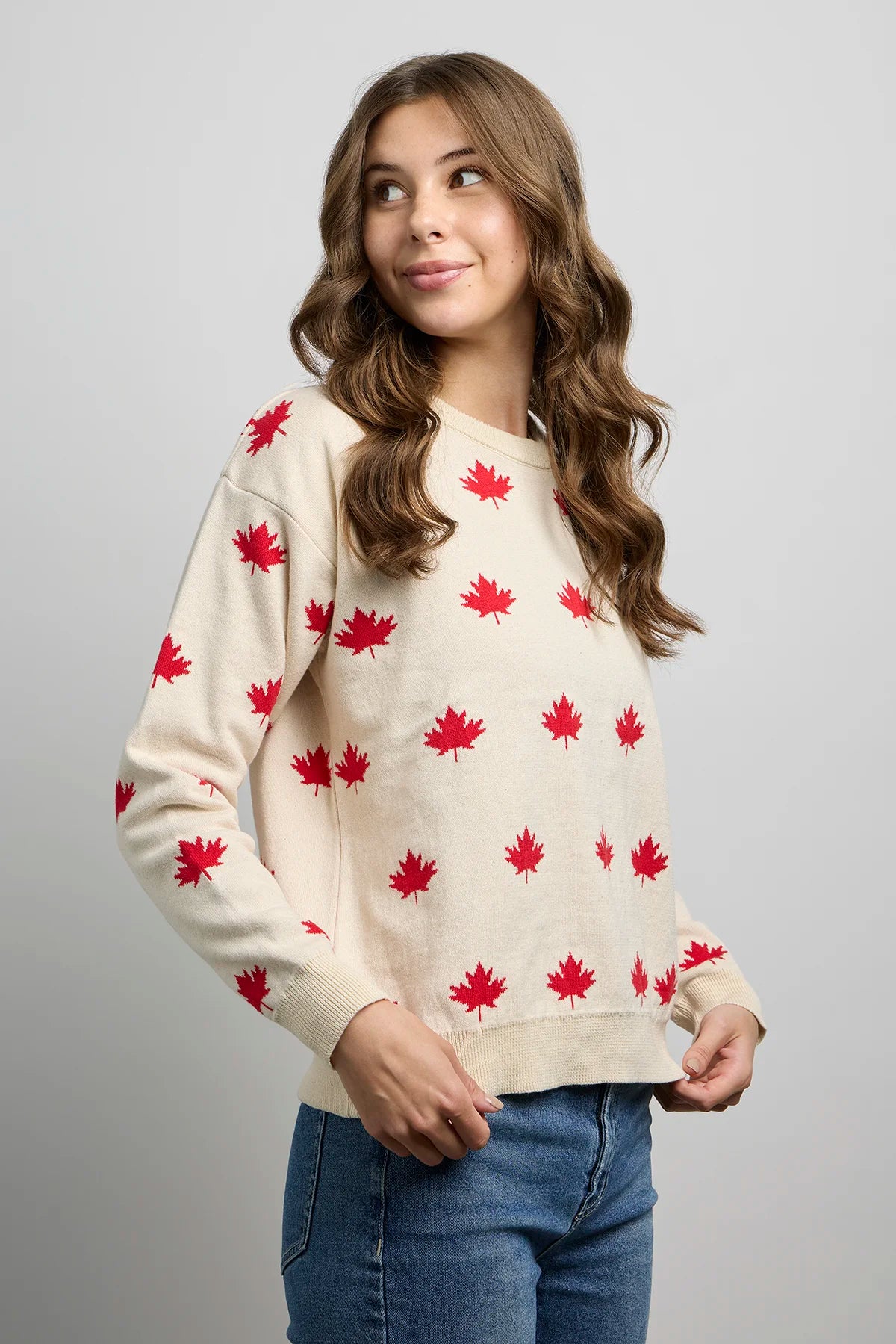 Front view of knit sweater with maple leaf pattern, long sleeves, ribbed crewneck, cuffs, and hem.