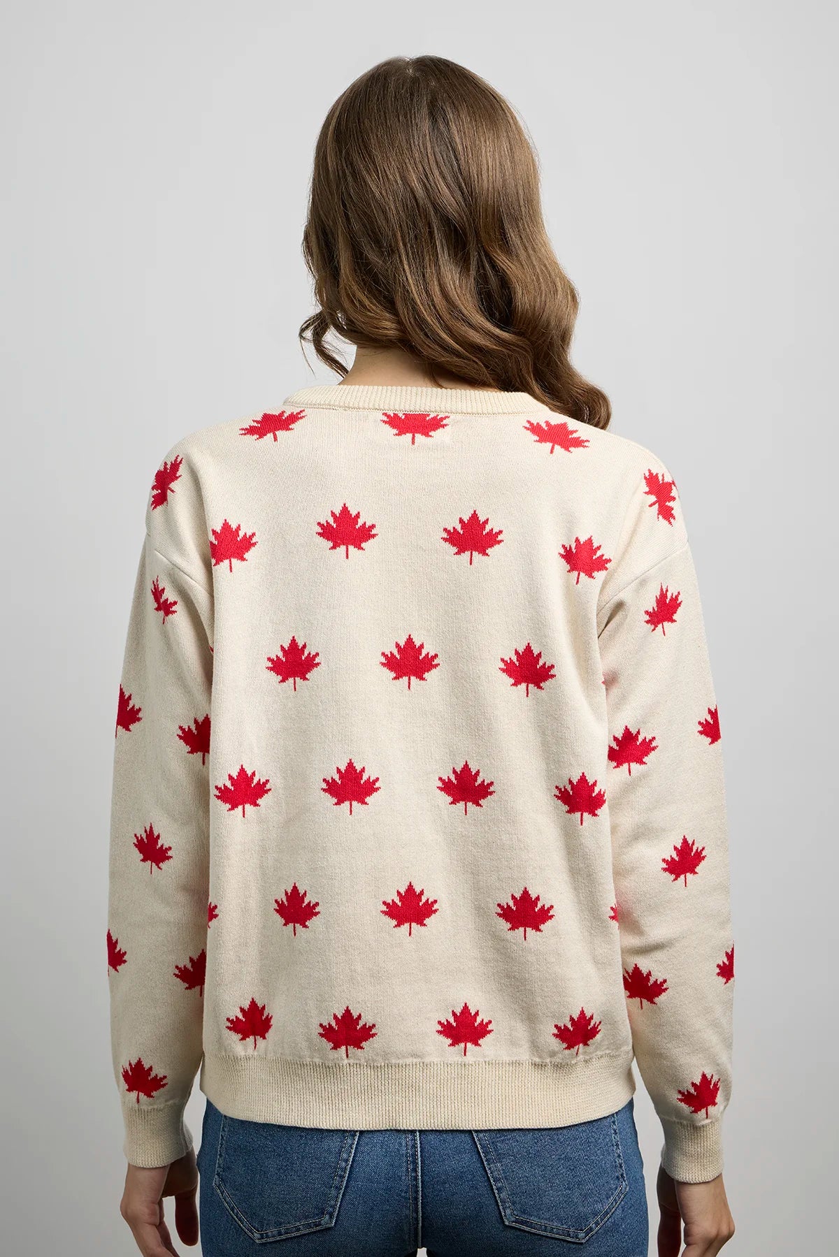 Back view of a knit sweater featuring an all-over maple leaf pattern with ribbed cuffs, hem, and crewneck.