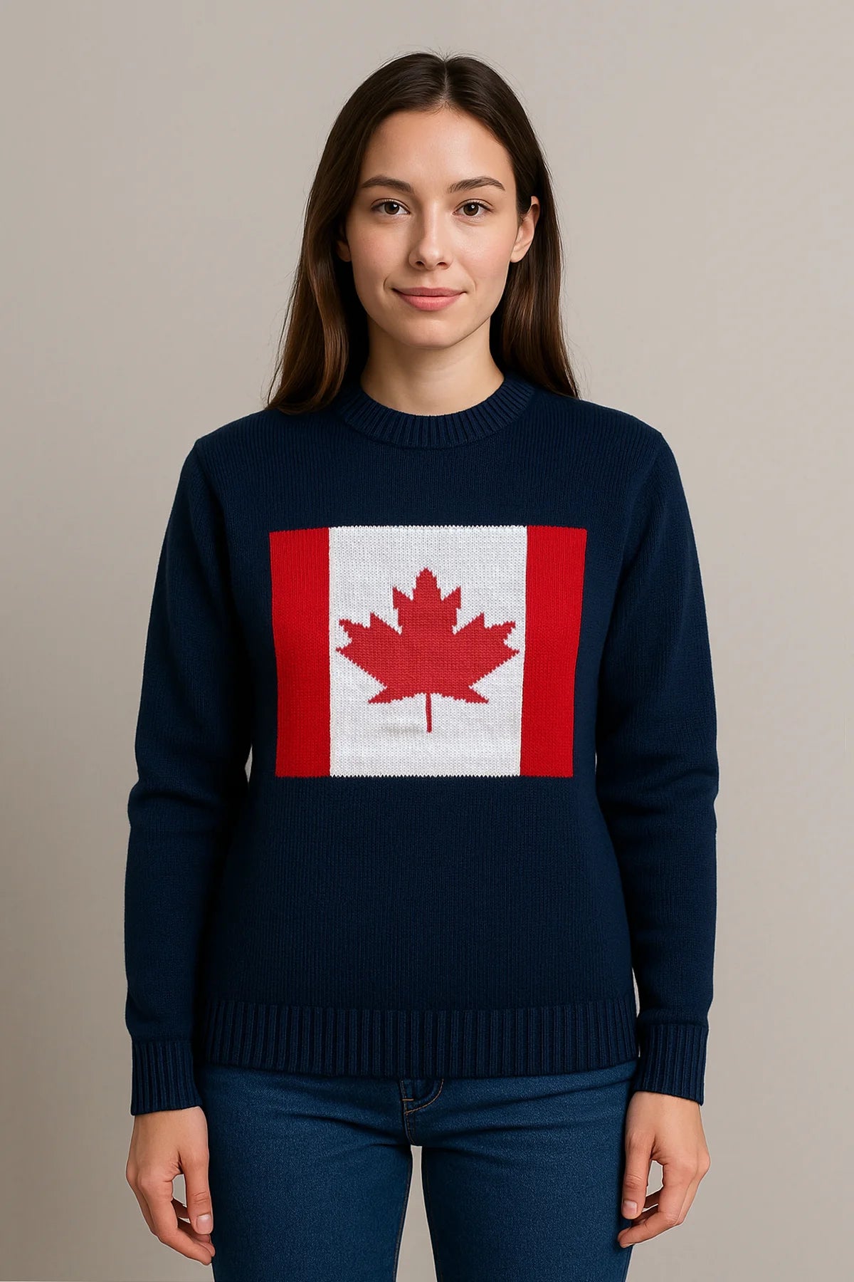 Woman wearing a navy blue sweater featuring a bold red and white Canadian flag design on the front, styled with blue jeans against a neutral background.