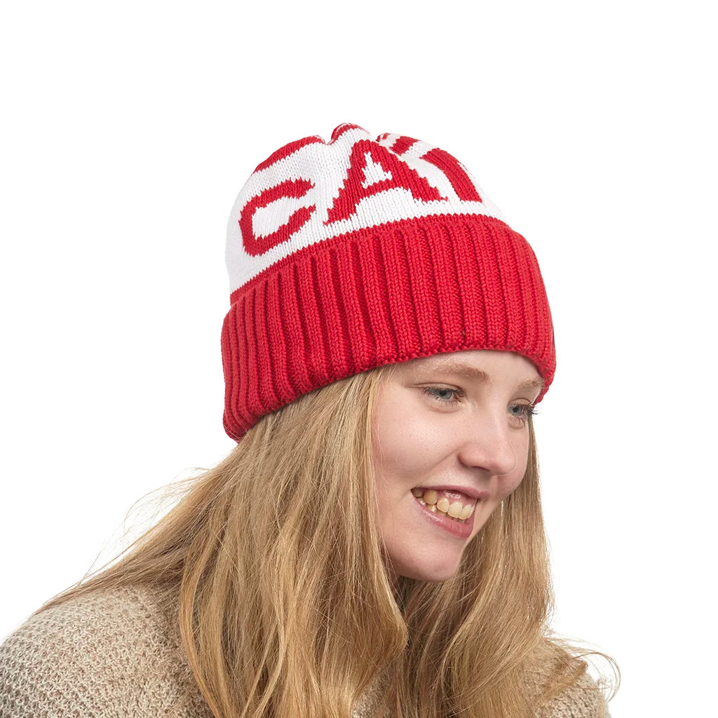 Person wearing a red and white beanie with a Canada Knitwear logo on a white background