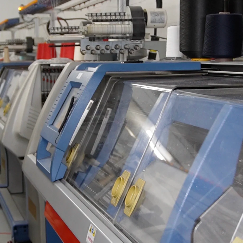 Modern computerized knitting machines in a Canadian textile facility, used for producing premium knitwear with precision and efficiency.
