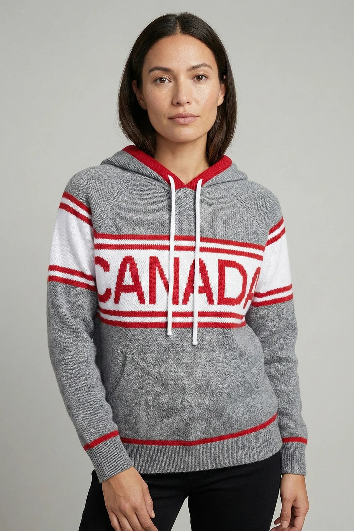 Person wearing a gray hoodie with 'Canada' printed on it against a plain background