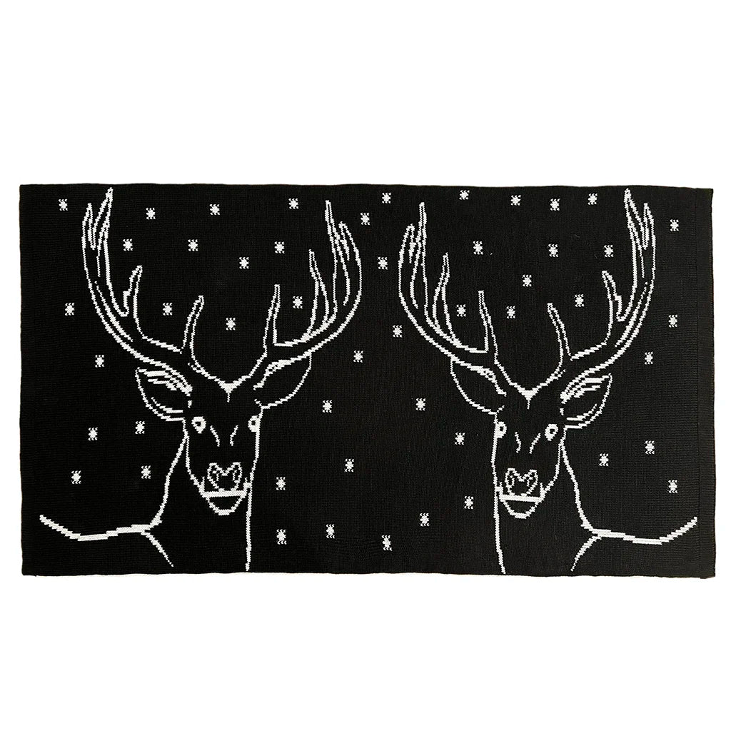 Black rug with white deer designs and star patterns on a white background