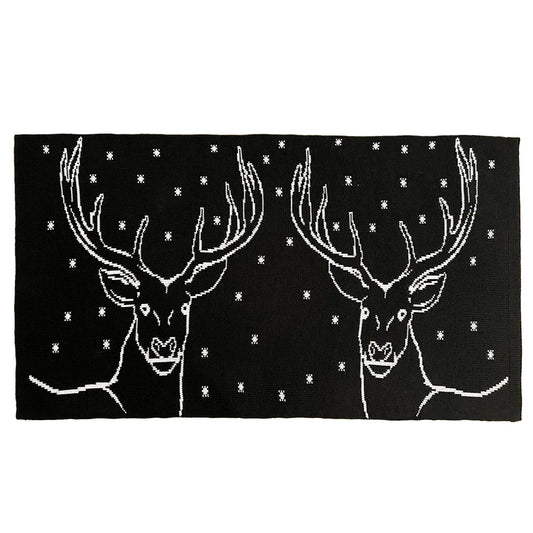 Black rug with white deer designs and star patterns on a white background