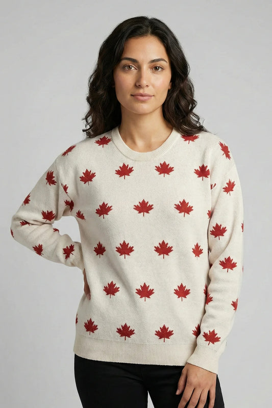 Woman wearing a cream sweater with red maple leaf pattern against a plain background