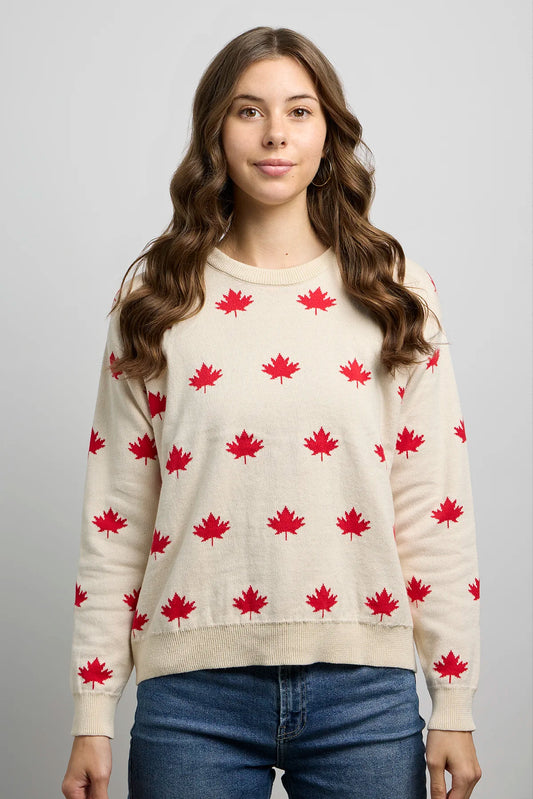 Front view of knit sweater with maple leaf pattern, long sleeves, ribbed crewneck, cuffs, and hem.
