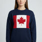 Person wearing a navy blue sweater with a Canadian Flag design on a light gray background