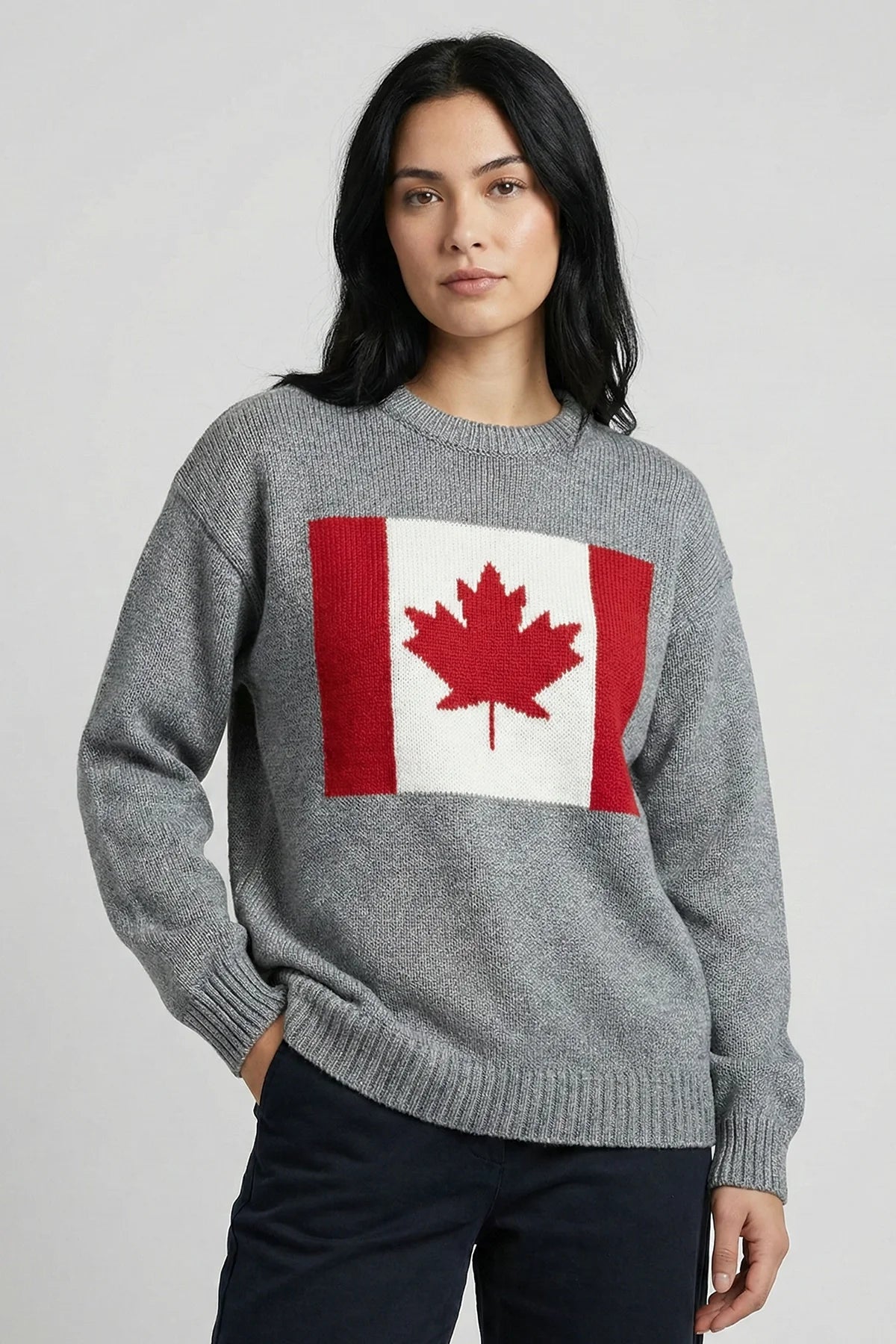 Person wearing a gray sweater with a Canadian flag design on a light gray background