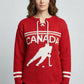 Person wearing a red sweater with 'Canada' and a hockey player silhouette on a gray background