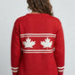 Red sweater with white maple leaf design on a plain background