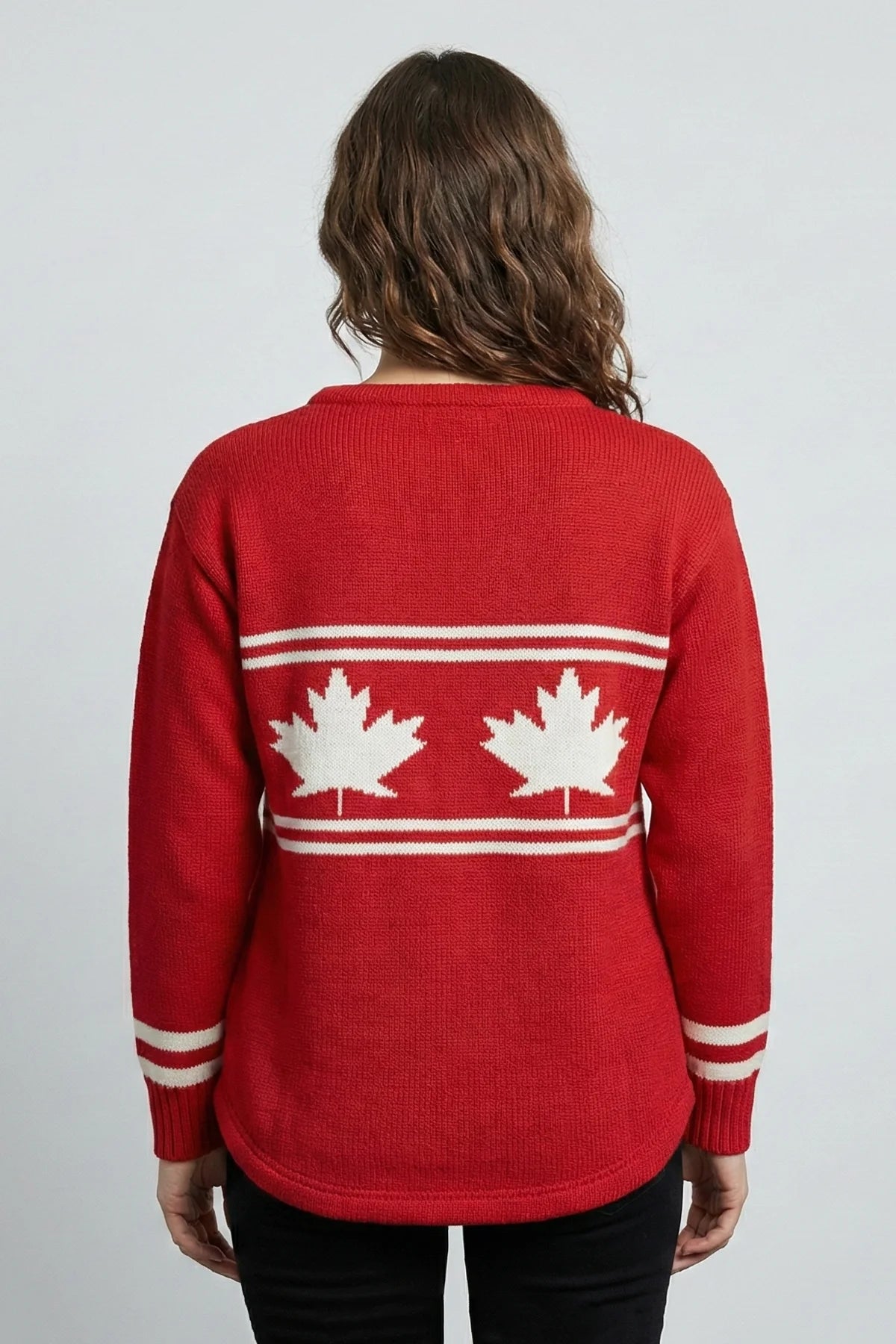 Red sweater with white maple leaf design on a plain background