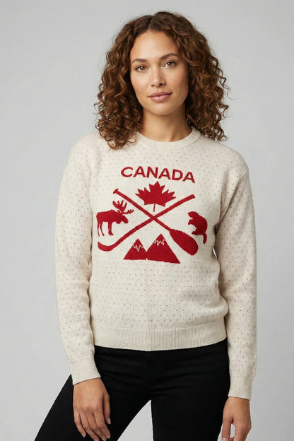 Woman wearing a cream sweater with red 'Canada' design featuring a maple leaf, moose, and mountains.