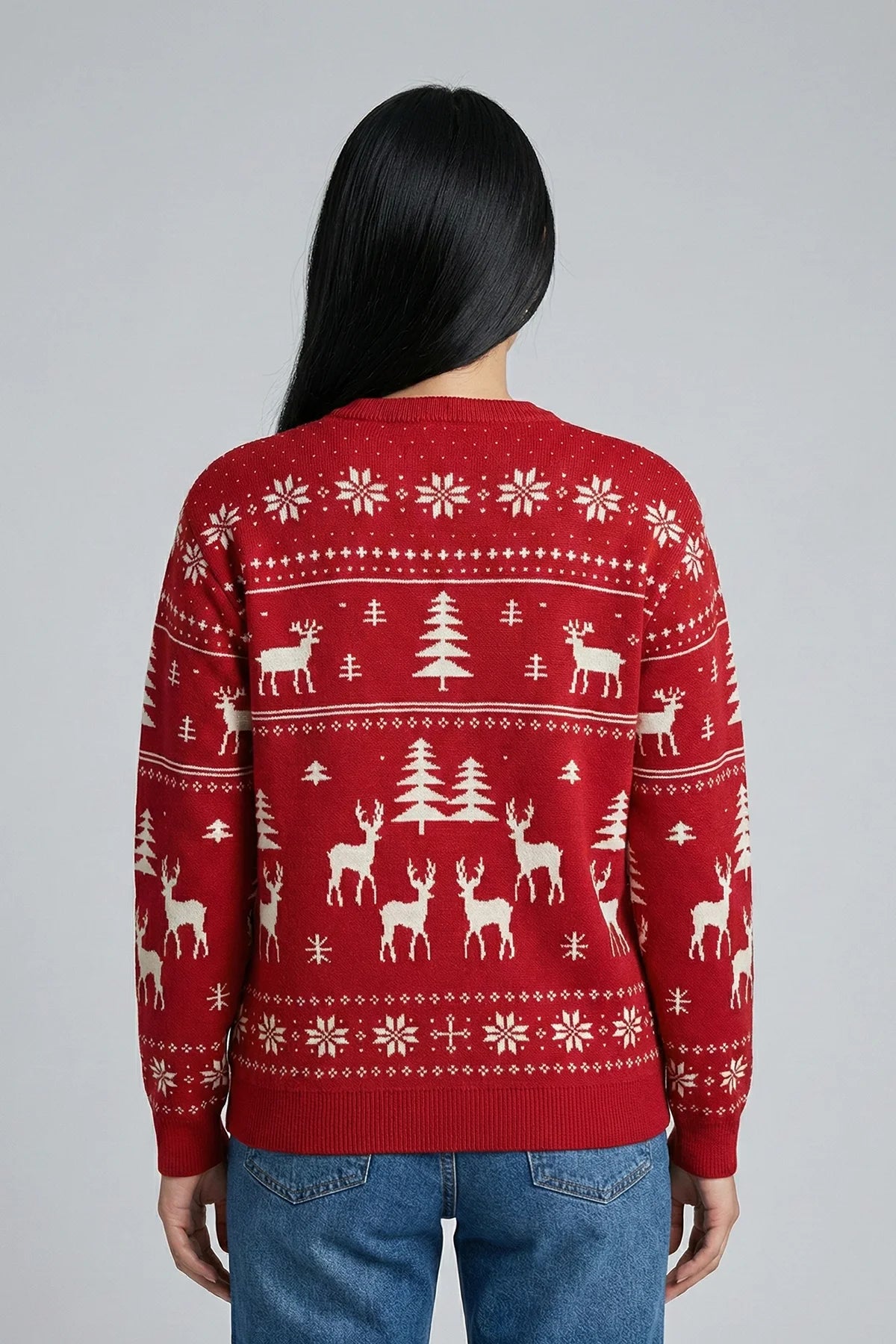 Person wearing a red sweater with reindeer and tree pattern on a gray background