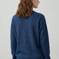 Woman wearing a blue sweater from behind on a light gray background