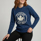Woman wearing a blue sweater with a Canada maple leaf design on a gray background