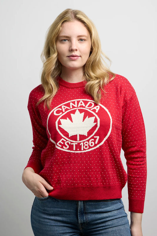 Front close-up of Sweater 1867 highlighting dotted knit pattern, ribbed crewneck, and bold maple leaf crest with Canada EST. 1867 text.