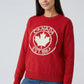 Person wearing a red sweater with 'Canada Est. 1867' design on a plain background