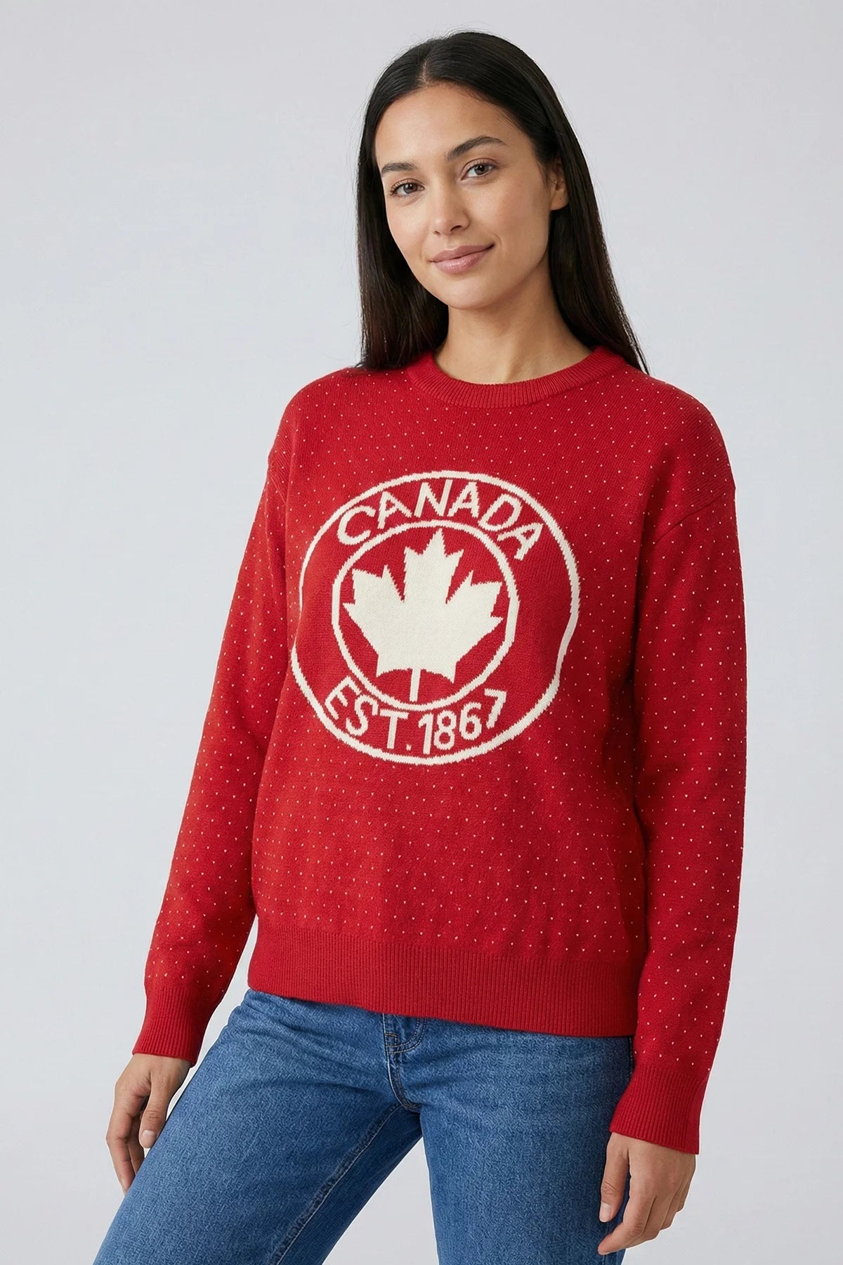 Person wearing a red sweater with 'Canada Est. 1867' design on a plain background