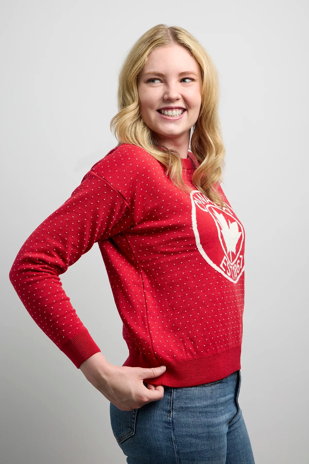Side view of Sweater 1867 showcasing knit fabric with dotted detailing and bold maple leaf crest design on the front.