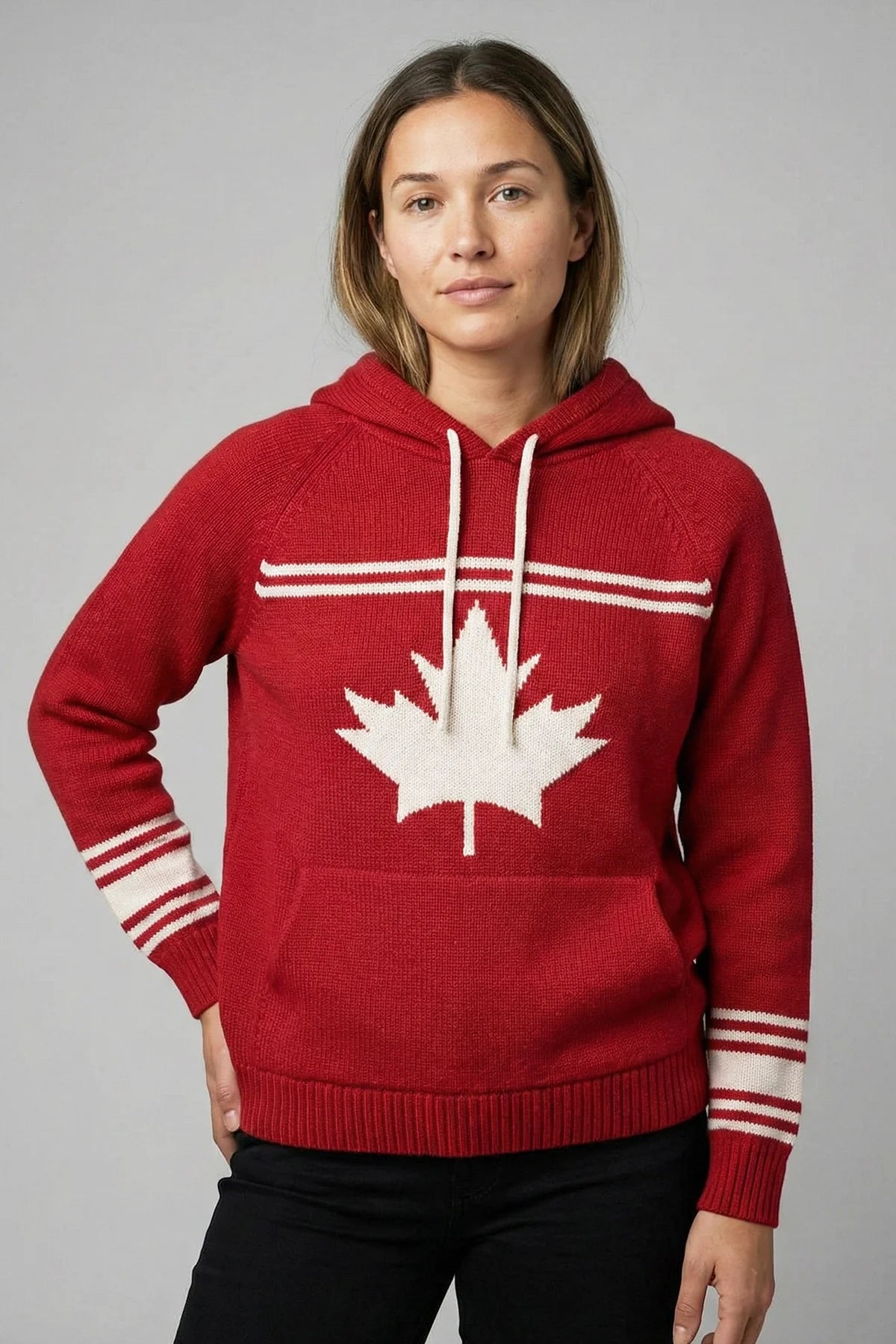 Person wearing a red hoodie with a white maple leaf design on a gray background
