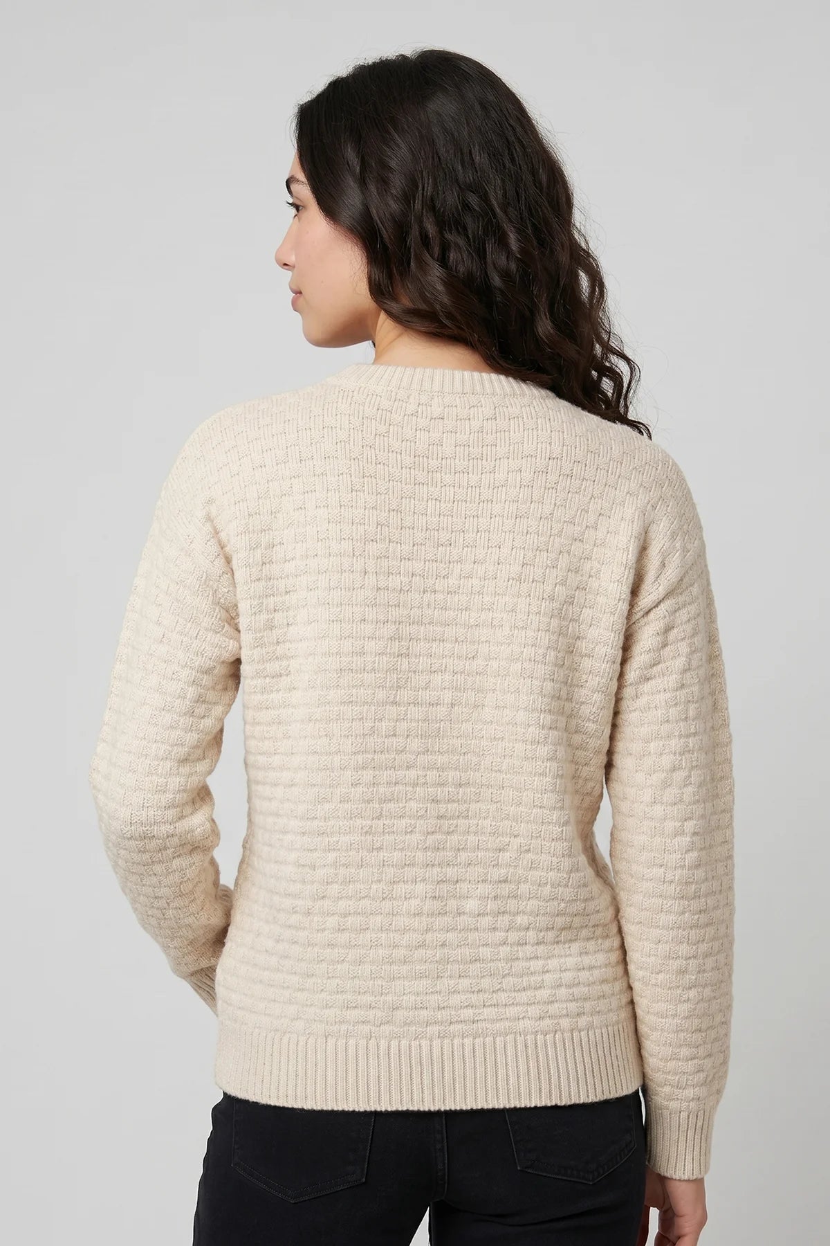 Back view of women’s cream waffle knit sweater featuring textured knit construction and ribbed hem detailing.