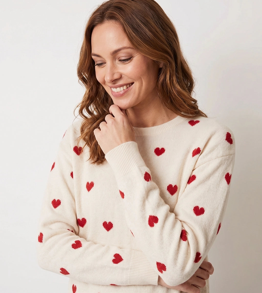 Women’s cream knit sweater with red heart pattern design and relaxed fit.